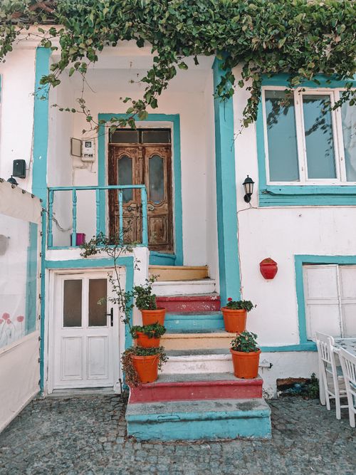 Free Colorful entrance of a Mediterranean-style house with vibrant potted plants and rustic door. Stock Photo