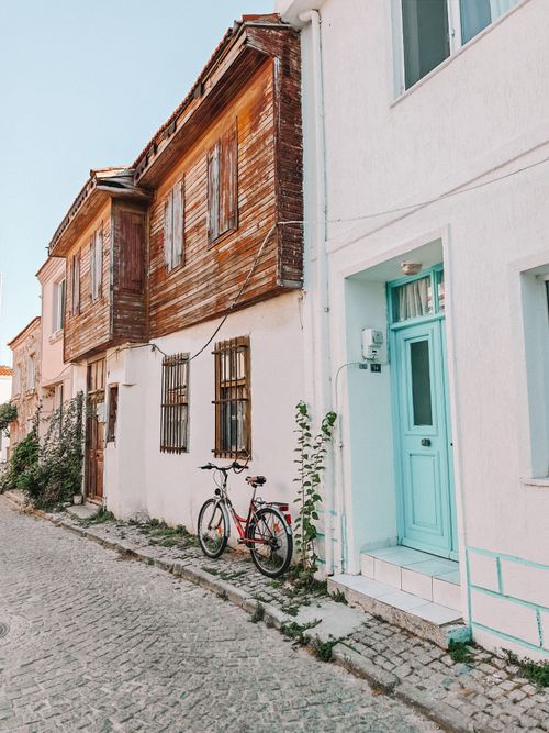 Free Explore a quaint cobblestone street with rustic wooden houses and a bicycle leaning against the wall. Stock Photo