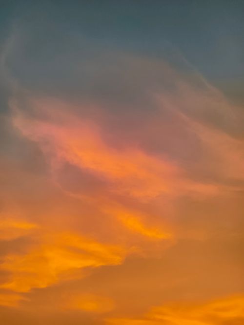 Free Captivating view of a vibrant sunset sky filled with orange clouds, creating a serene and artistic atmosphere. Stock Photo