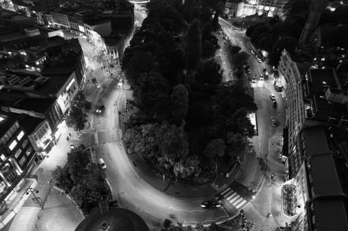 Free High-angle black-and-white photo of a vibrant urban roundabout at night, showcasing city life. Stock Photo