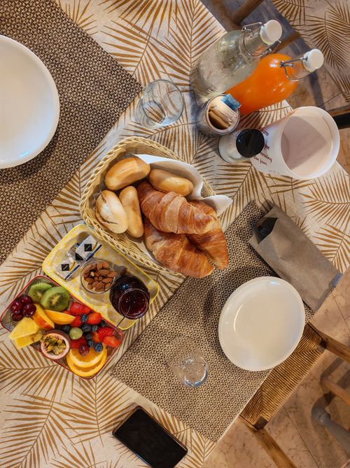 Free Top view of a breakfast table with croissants, fruit platter, and juices, ideal for lifestyle and food themes. Stock Photo