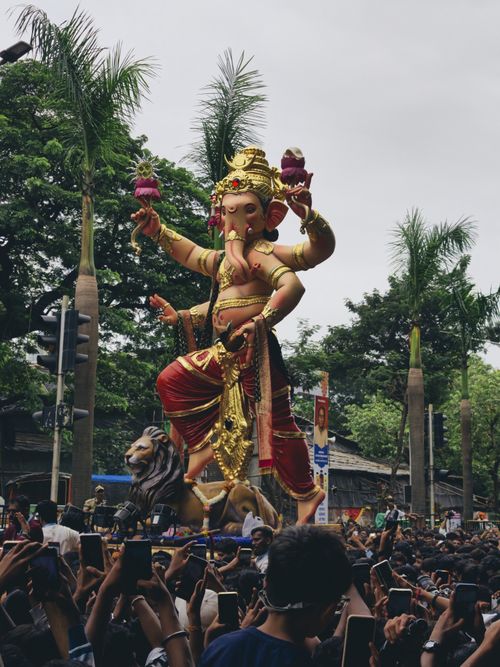 Free Vibrant Ganesh Chaturthi celebration in Mumbai with a large Ganesh idol and a crowd of devotees. Stock Photo