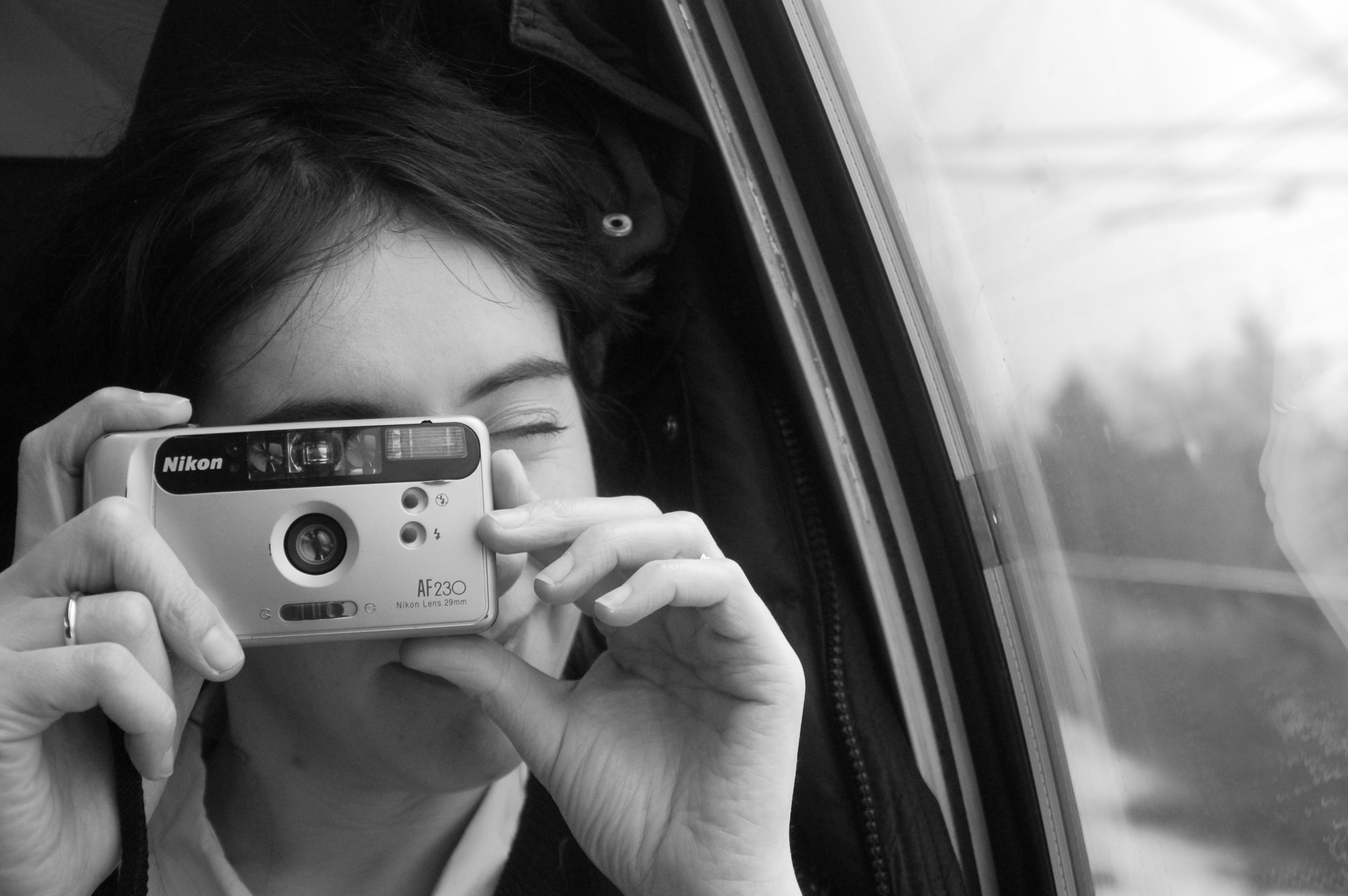 A person with a camera captures a moment in monochrome style.