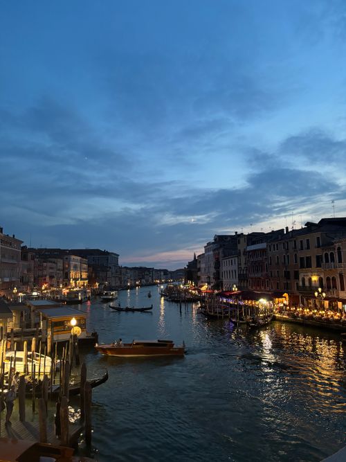 Free Stunning twilight scene of Venice's Grand Canal with gondolas and illuminated buildings. Stock Photo