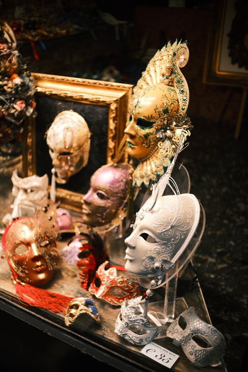 Free A captivating display of ornate Venetian masks in a dimly lit setting, highlighting intricate details. Stock Photo