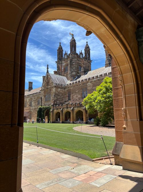 Free View through stone arch of historic University Quadrangle in Camperdown, Australia. Stock Photo