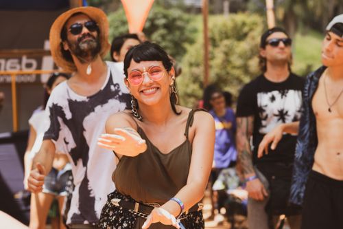 Free Happy people enjoying music and dancing at an outdoor festival in the sun. Stock Photo
