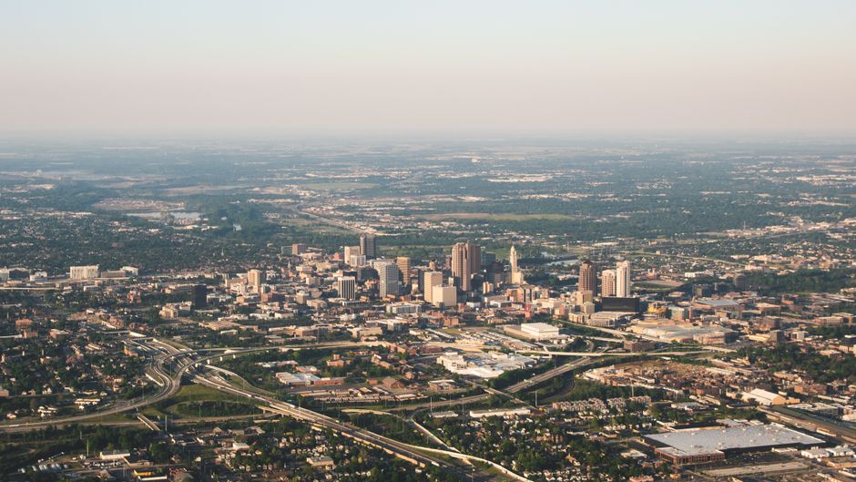 Aerial photograph showcasing the sprawling cityscape of Columbus, Ohio during the day.