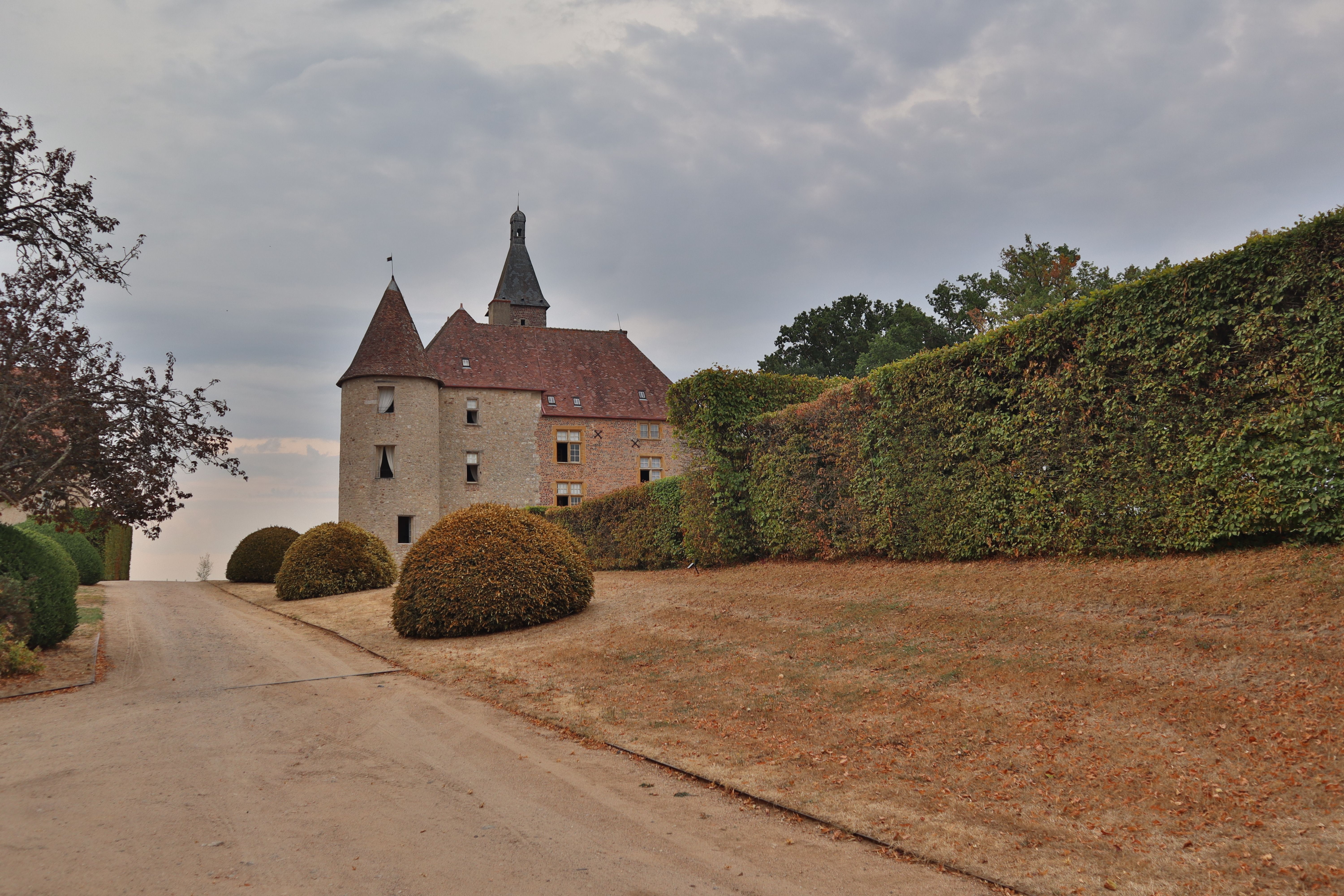 Historic chateau on castle grounds in Saint-Pourçain-sur-Besbre, France, during fall.