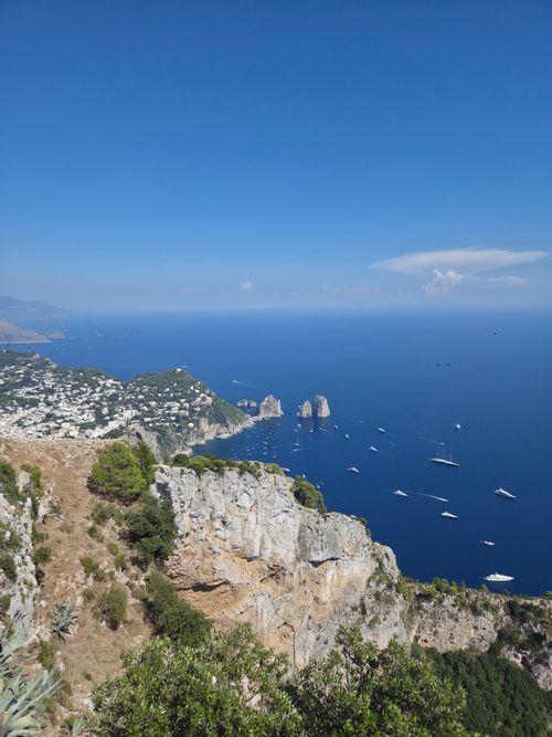 Free Stunning aerial shot of Capri, Italy, showcasing the famous Faraglioni rock formations in bright summer daylight. Stock Photo