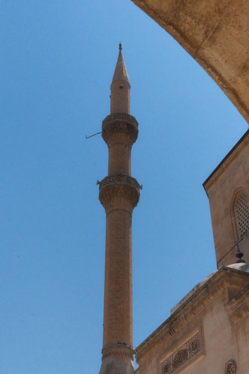 Free A tall minaret stands majestically against a clear blue sky, capturing architectural elegance. Stock Photo