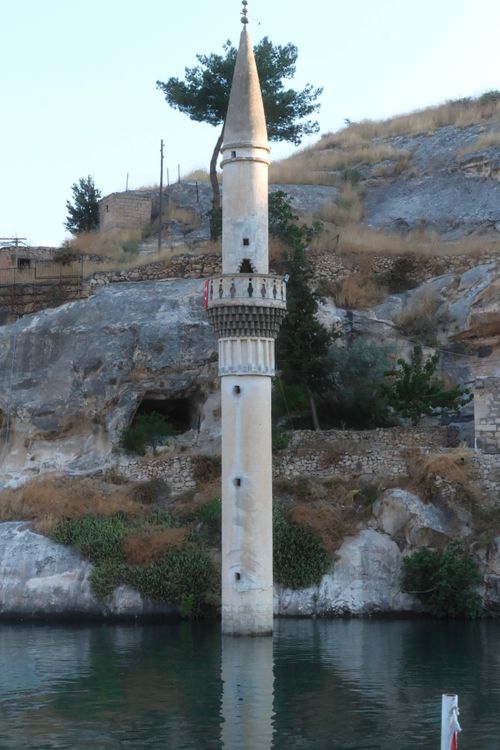 Free A picturesque view of a historic minaret submerged in a tranquil lake. Stock Photo