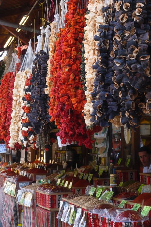 Free Vibrant market scene featuring hanging dried vegetables and spice stalls in an outdoor setting. Stock Photo