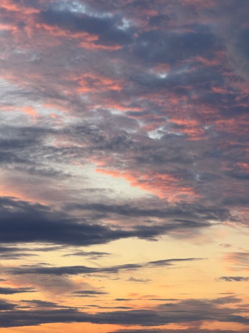 Free A breathtaking sunset with vibrant colors and dramatic cloud formations filling the sky. Stock Photo