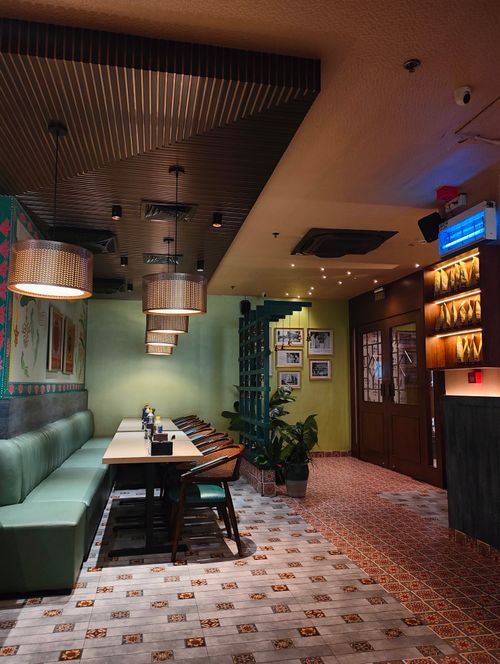 Free Chic Indian restaurant interior with contemporary decor, colorful tiles, and ambient lighting. Stock Photo