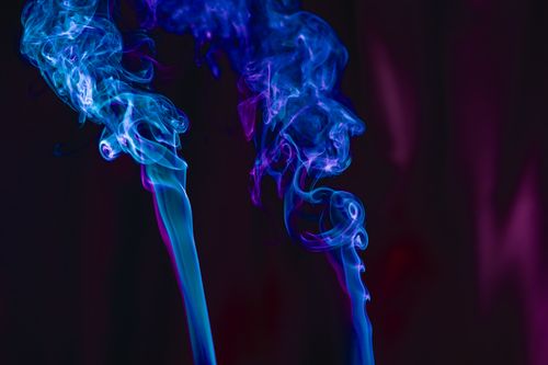 Free Captivating abstract image of blue and purple swirling smoke on a dark background. Stock Photo