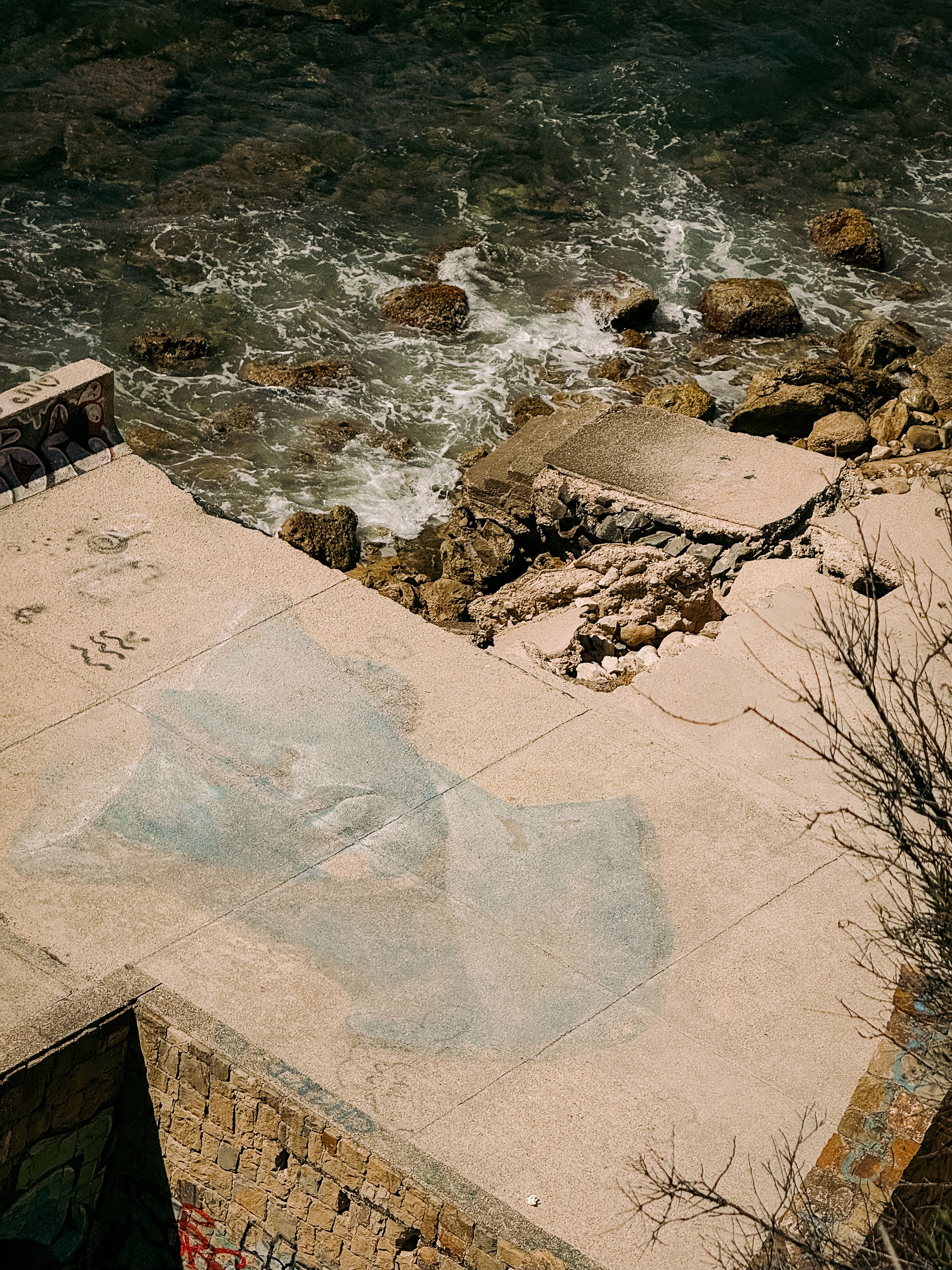 Concrete mural overlooking the sea with artistic graffiti in Calp, Spain.