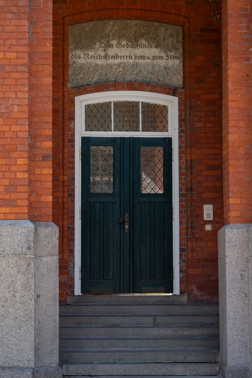 Free A detailed view of an ornate wooden door set in a red brick building, historic charm. Stock Photo