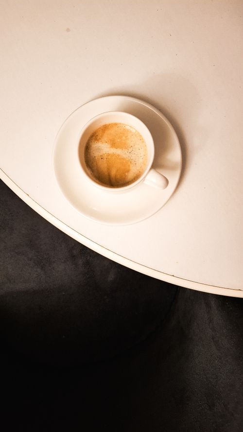 Free Cup of espresso on a round white table viewed from above, offering a cozy and inviting feel. Stock Photo