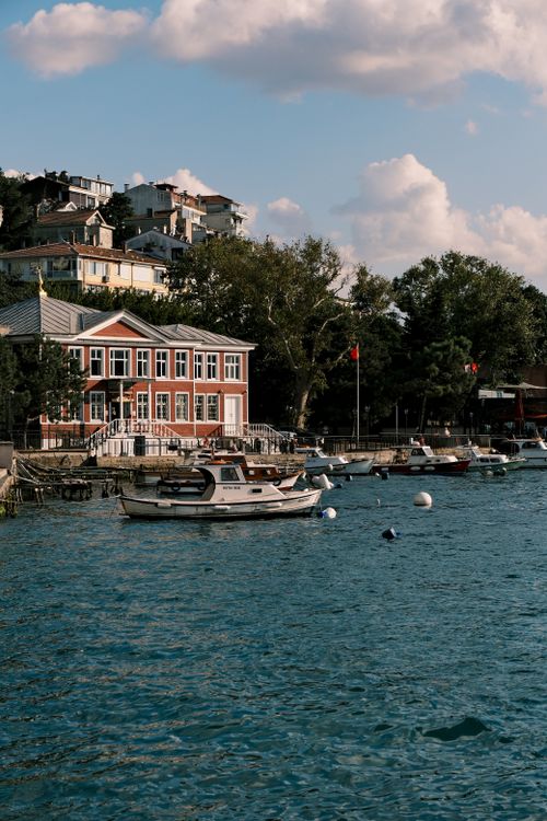 Free Tranquil waterfront scene with moored boats and charming architecture under a blue sky. Stock Photo