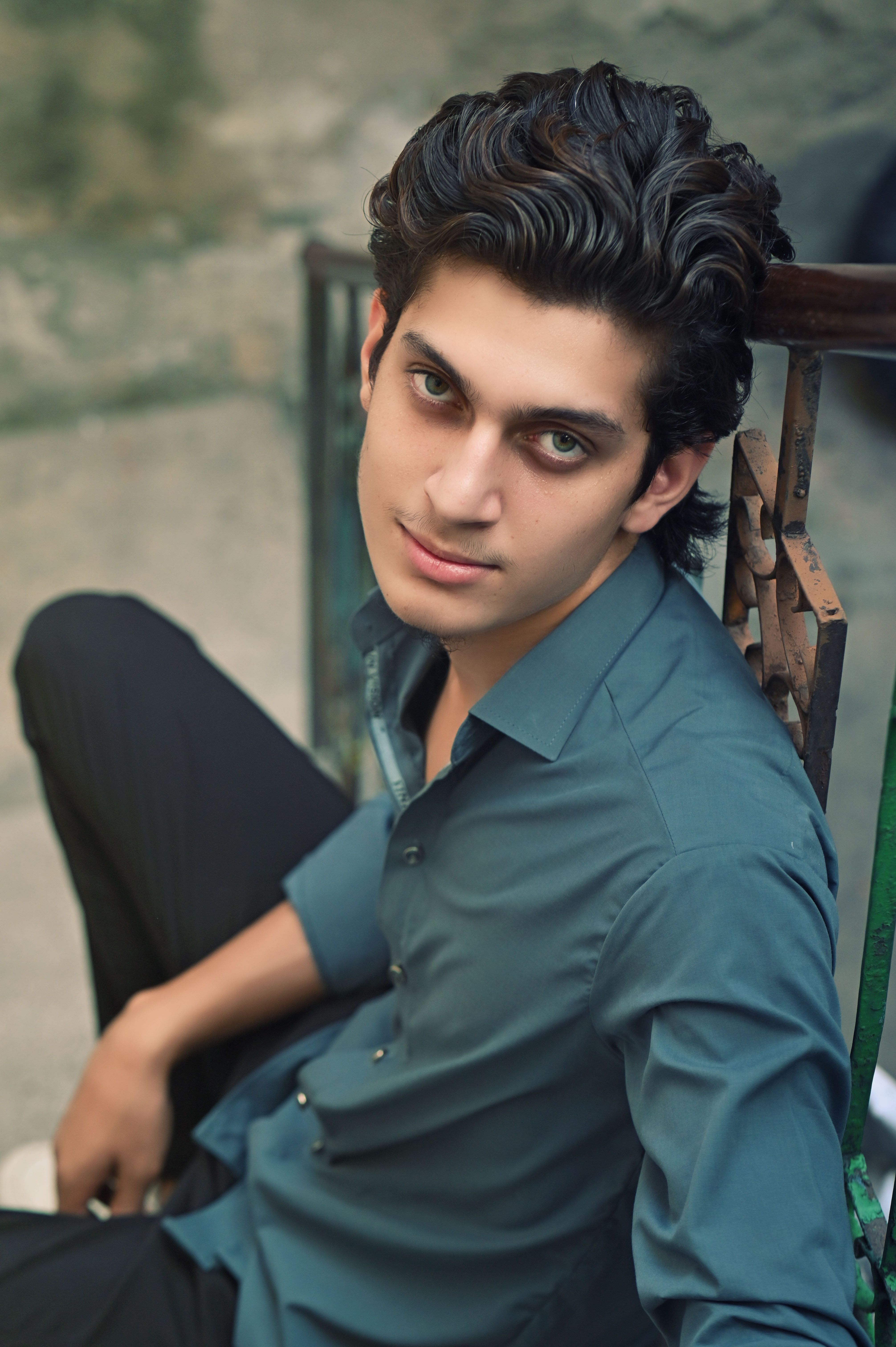 Stylish young man in a relaxed pose outdoors, exuding confidence.