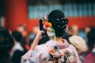 日本节日上，女子穿着和服、戴着花卉头饰的后视镜