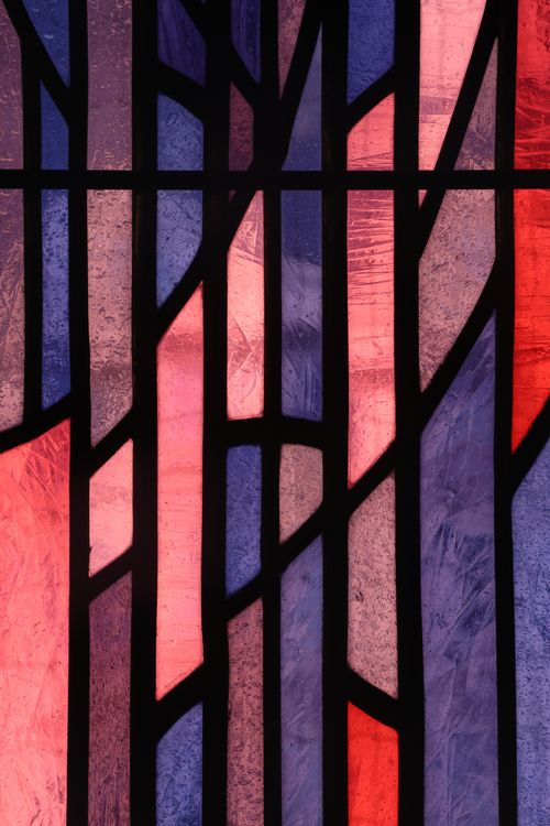 Free Vibrant stained glass panel with geometric design, blending red and purple hues. Stock Photo
