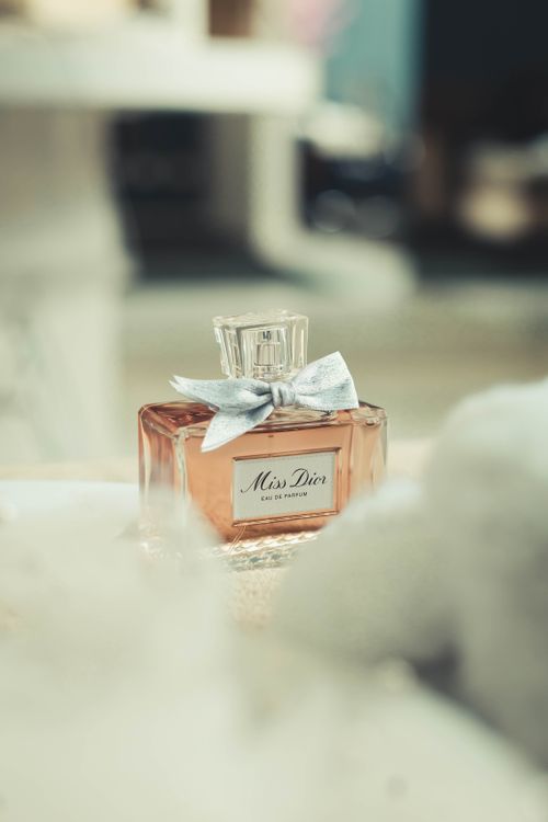 Free Aesthetic close-up of Miss Dior perfume bottle with a delicate bow, showcasing sophistication. Stock Photo