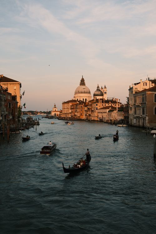 Free Tranquil scene of gondolas on Venice's Grand Canal at sunset, showcasing historic architecture. Stock Photo