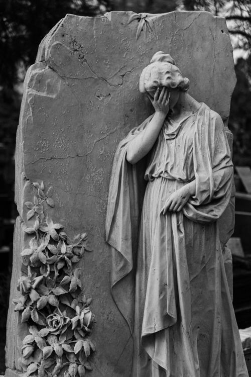 Free A black and white photo of a grieving statue in a São Paulo cemetery. Stock Photo