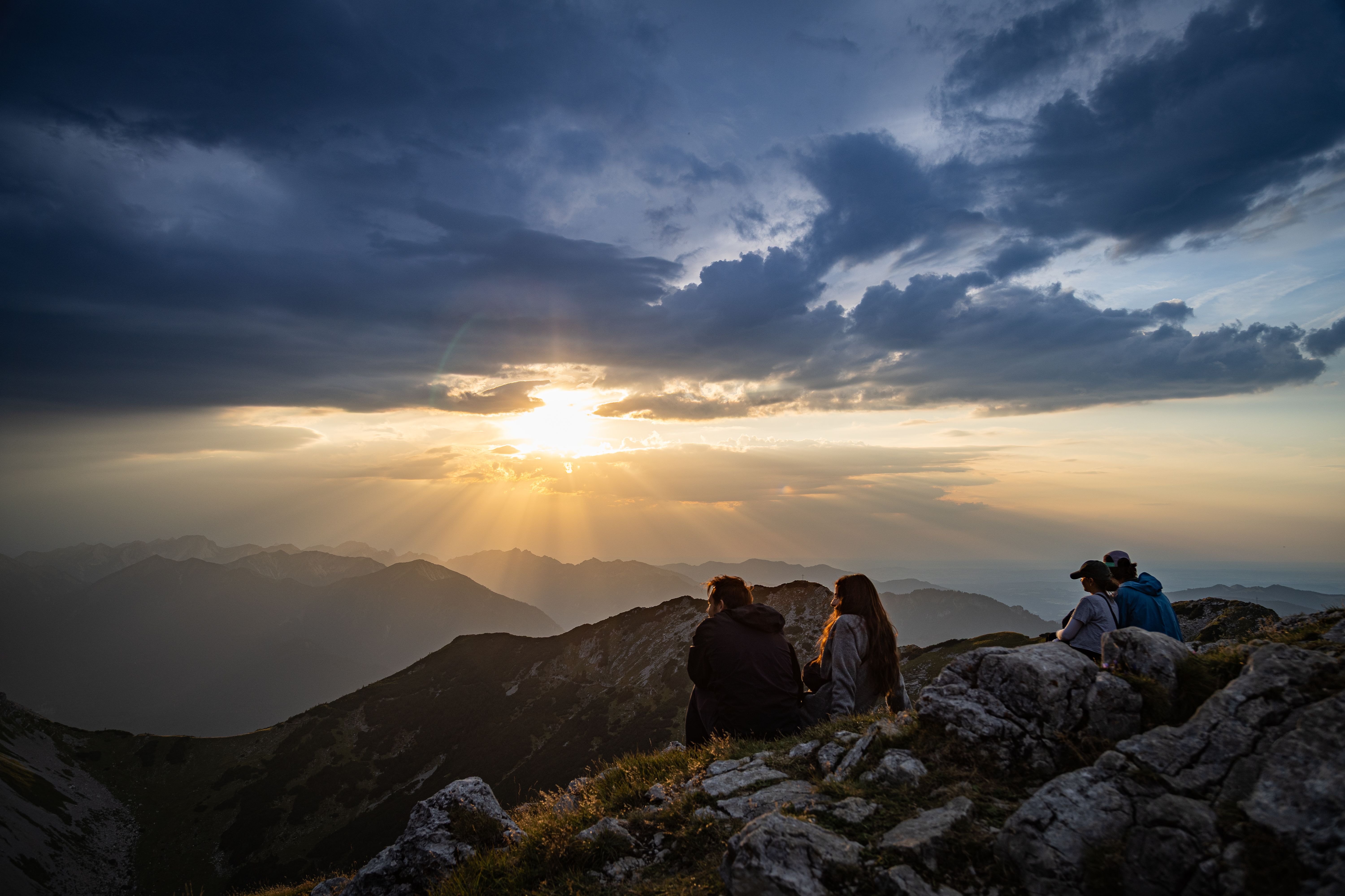 A group of walkers on a ridge watching the sun go down