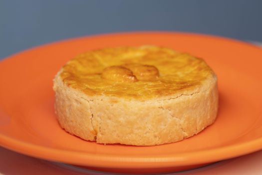 Delicious homemade savory pie on a vibrant orange plate, perfect for culinary presentations.