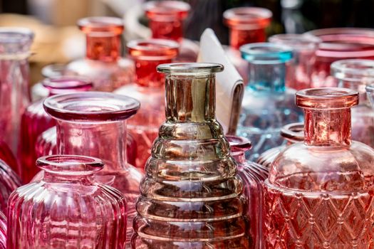 Vibrant glass bottles displayed at an outdoor market showcasing colorful reflections.