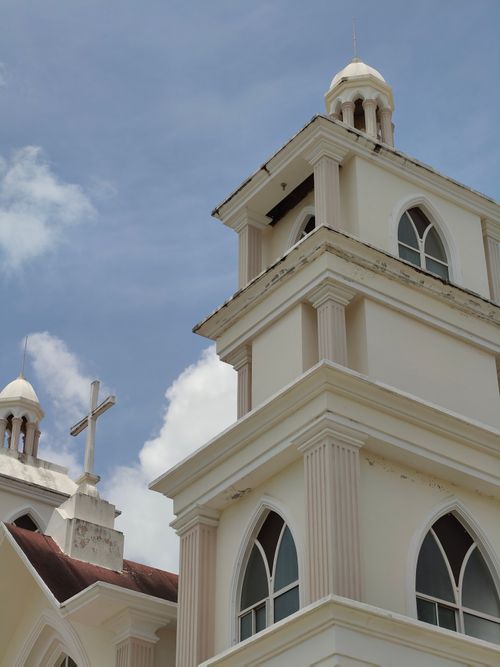 Free Close-up of a church tower with a cross against a clear sky, showcasing elegant architecture. Stock Photo