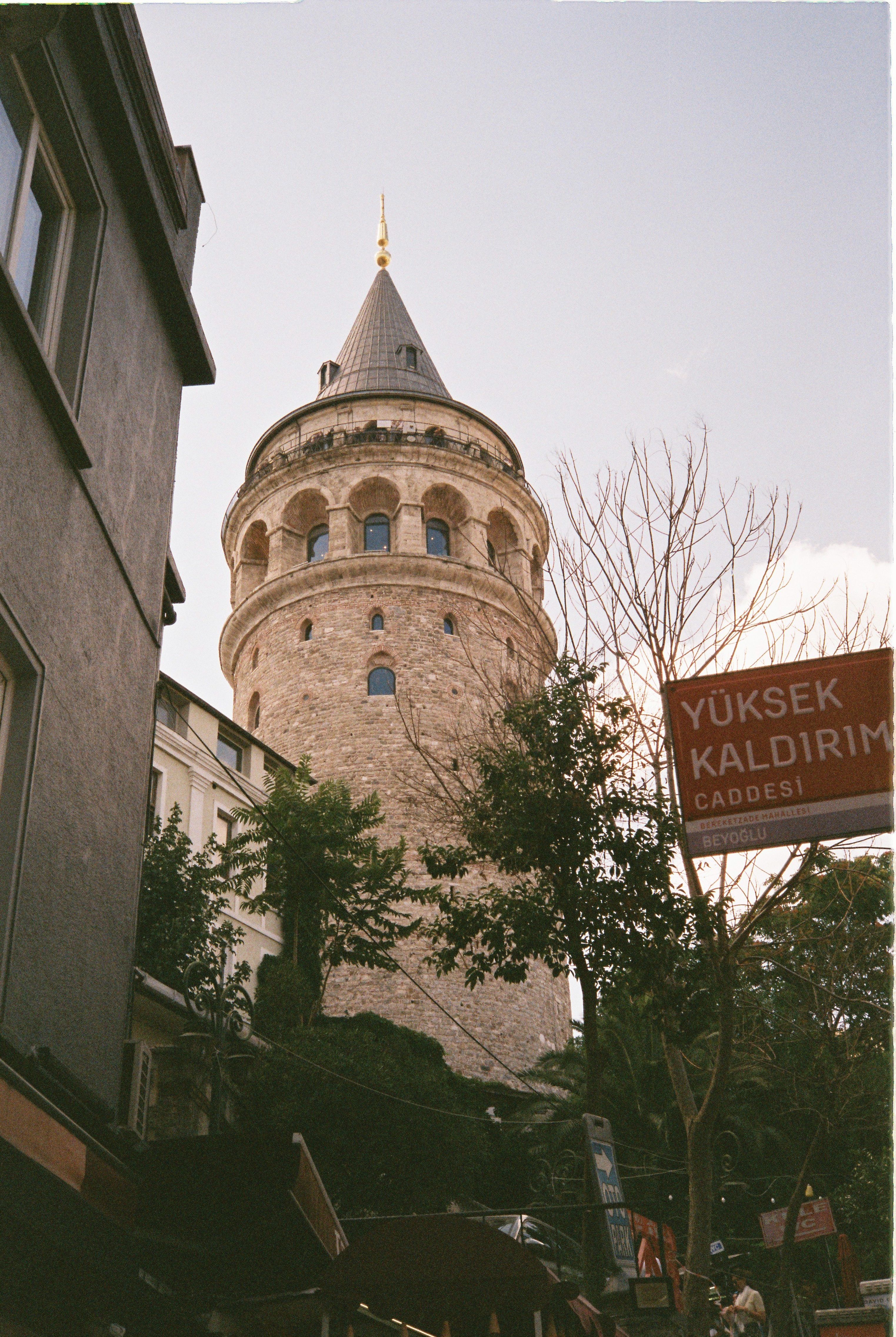 View of the historic Galata Tower in İstanbul, Türkiye, against a clear sky.