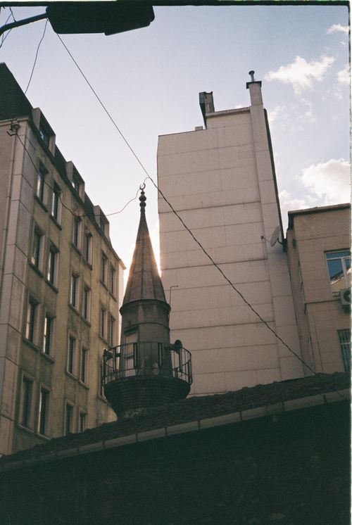 Free A striking view of a historic minaret against modern buildings in İstanbul, Türkiye. Stock Photo
