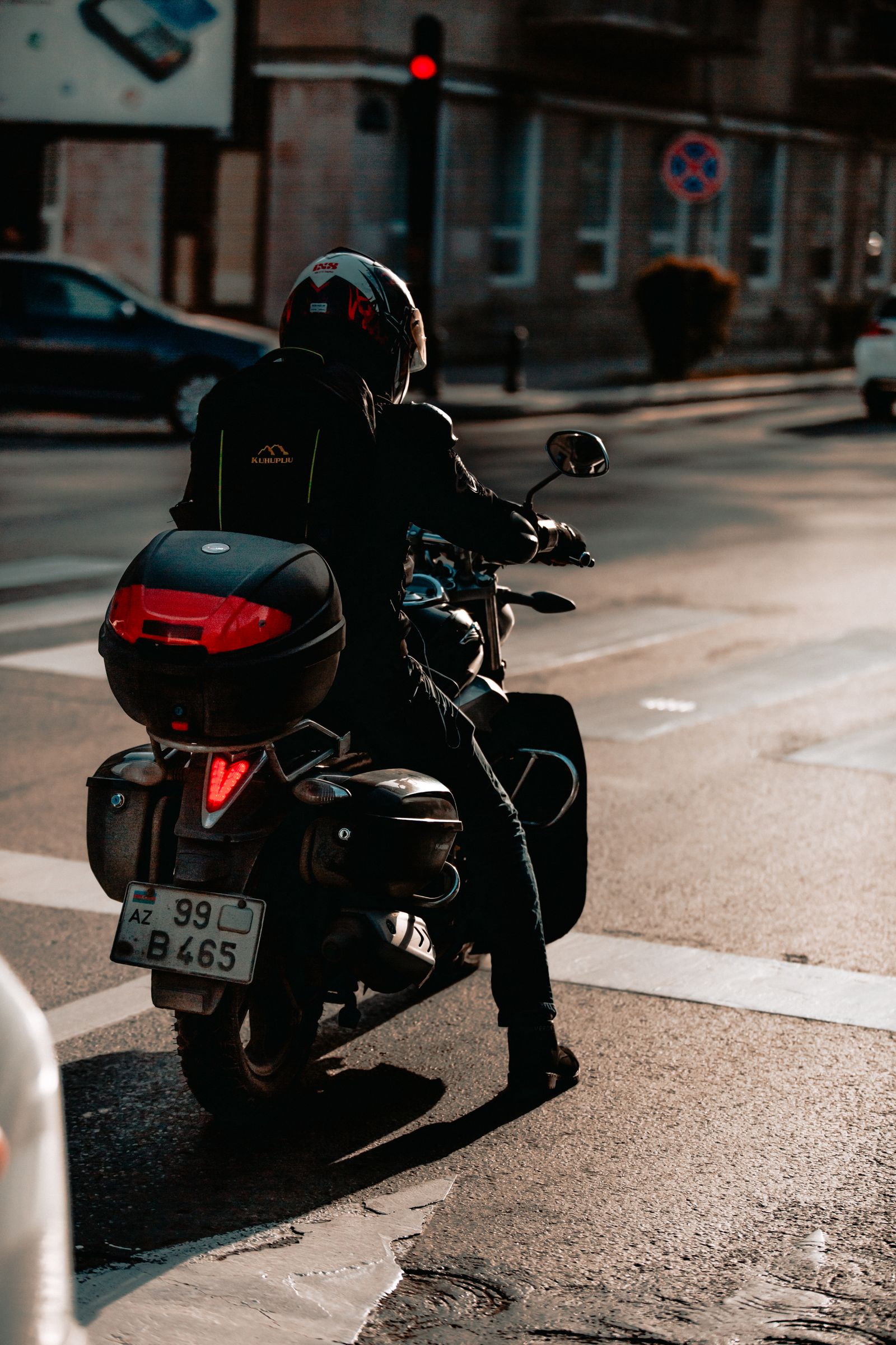 Motard casqué arrêté à un feu rouge en ville