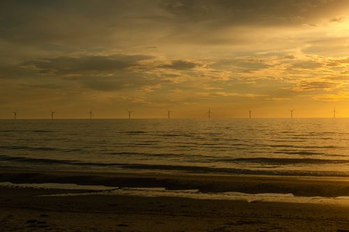 Free Golden sunset view with wind turbines at Vestervig, Denmark, capturing the tranquil beauty of sustainable energy. Stock Photo