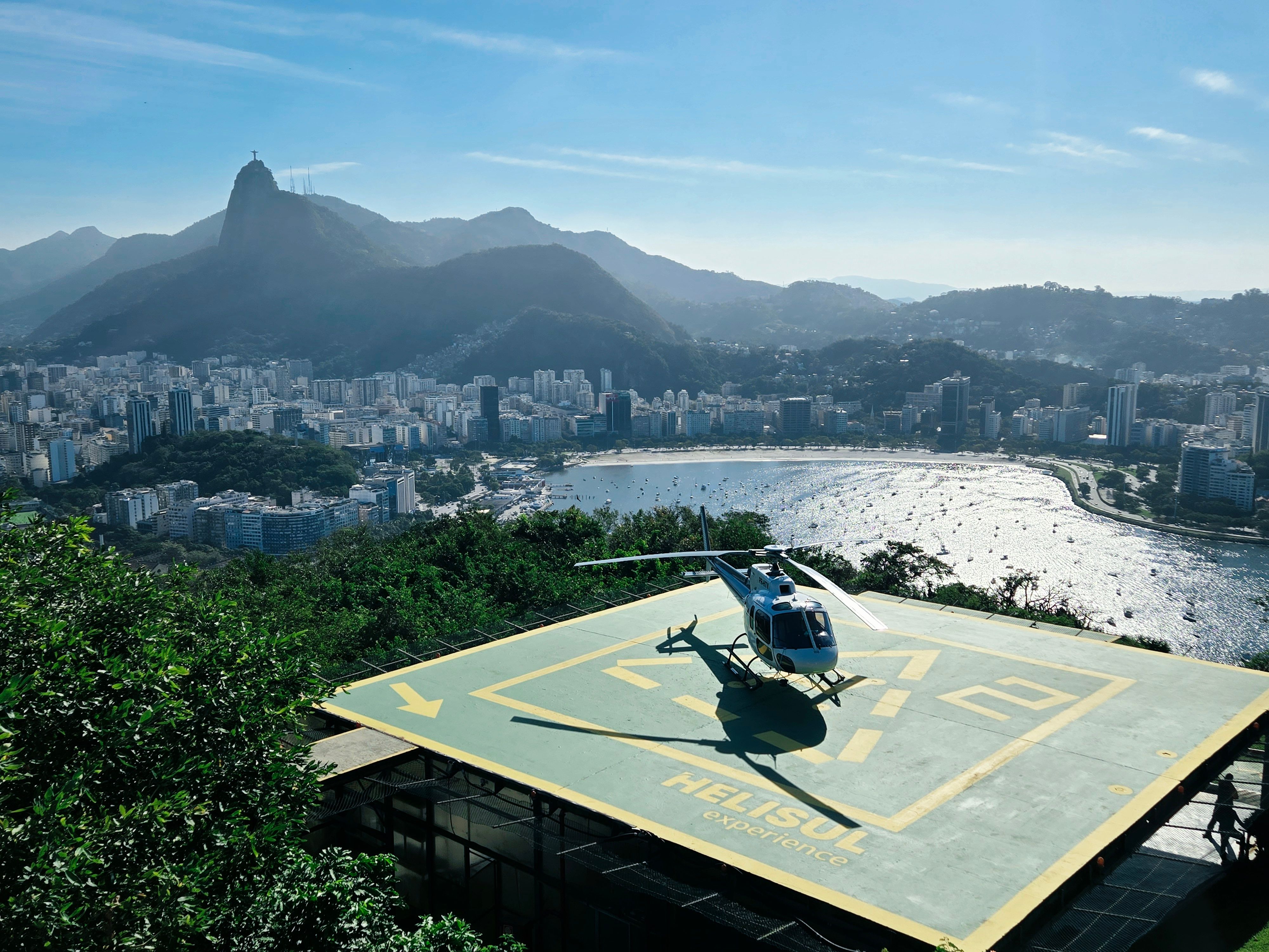 Helicopter on a helipad with Christ the Redeemer statue in Rio de Janeiro.