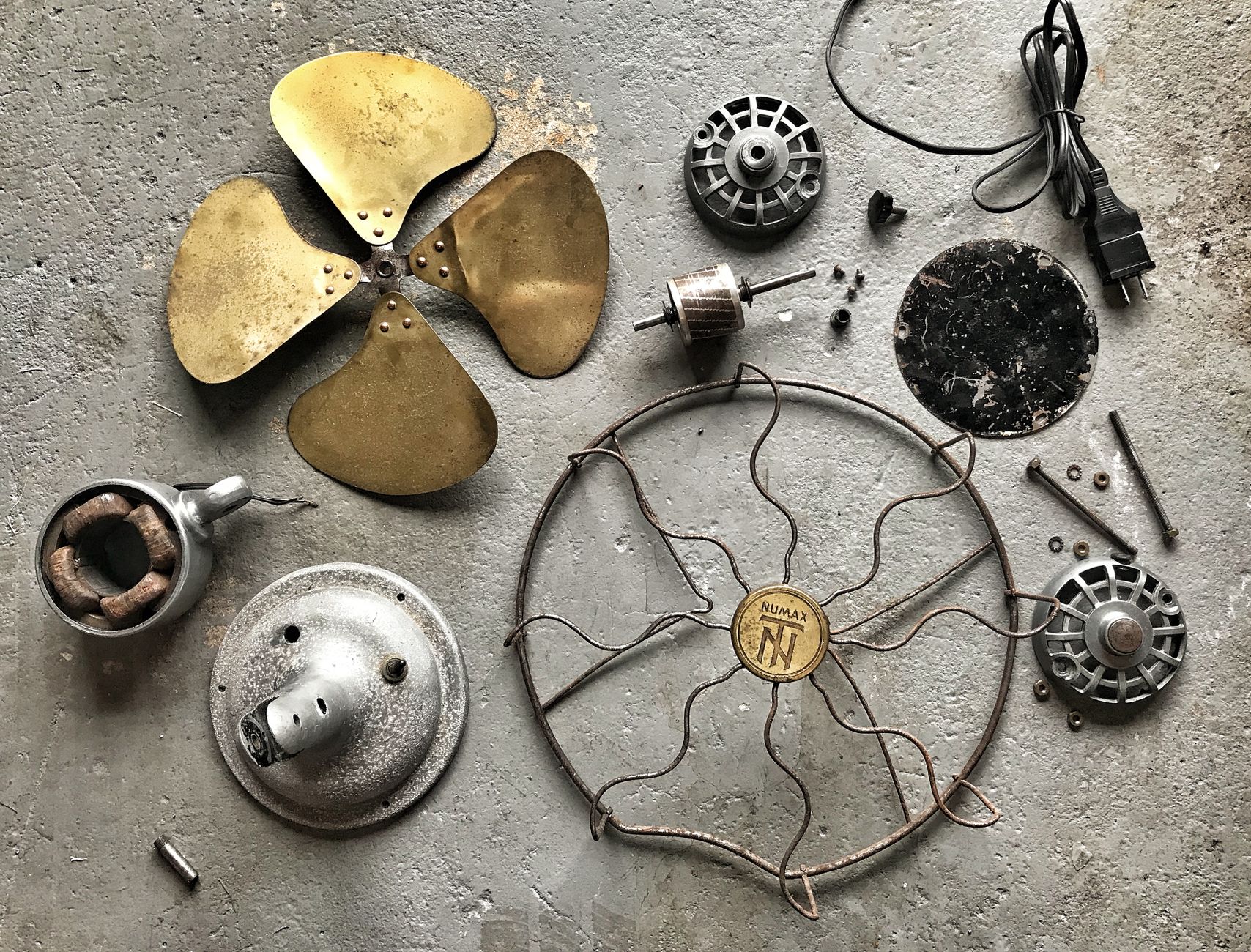 From above of retro details from vintage broken fan spread on concrete floor