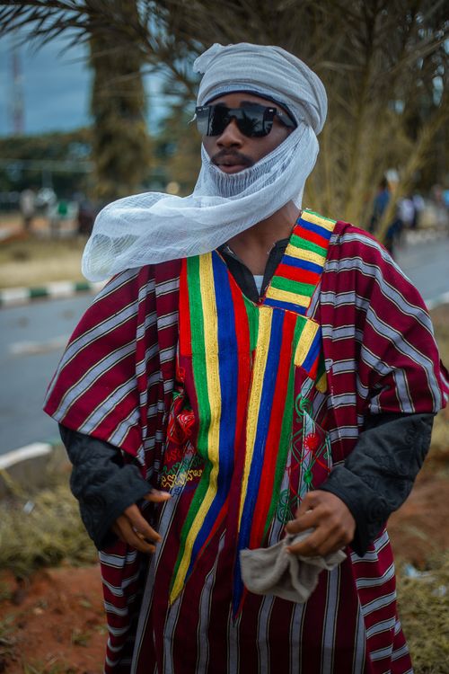 Free Man in vibrant Hausa attire, outdoors in Nigeria, showcasing cultural heritage. Stock Photo