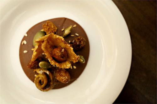 Free Top view of a gourmet chocolate dessert with nuts and seeds on a white plate. Stock Photo