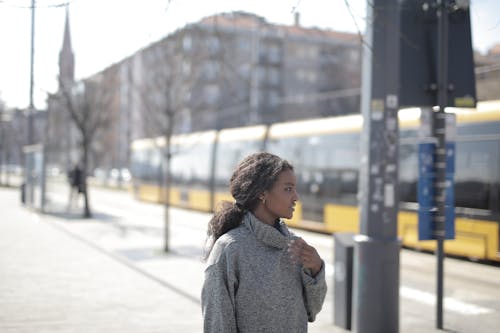 Woman in Gray Sweater Standing on Sidewalk