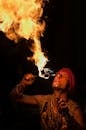 在一场戏剧性的夜间表演中，一位男性火表演者展示了令人印象深刻的食火技巧