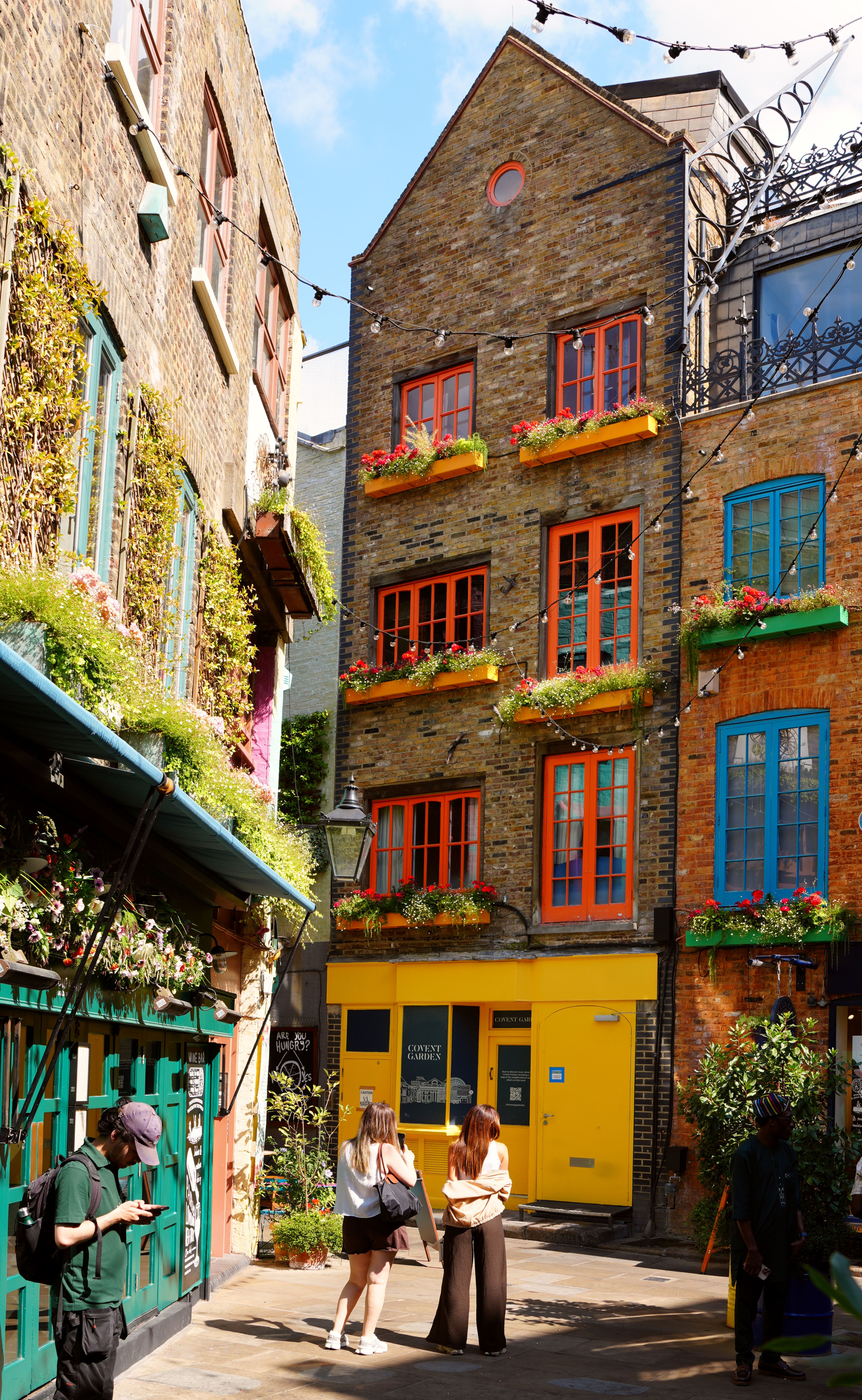 Vibrant Neal's Yard with colorful facades and people in Covent Garden, London, UK.