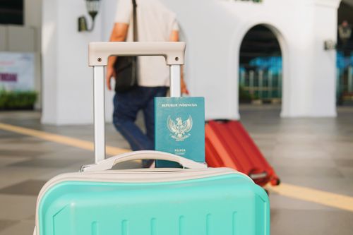 Free Traveler arrives at Yogyakarta airport, Indonesia with luggage and Indonesian passport in focus. Stock Photo