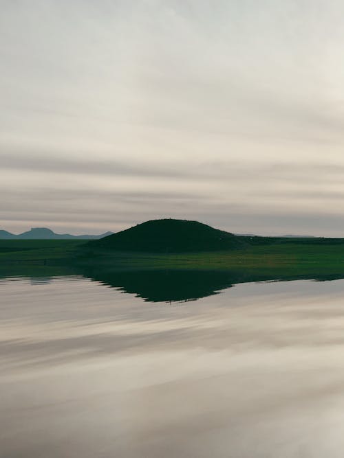 Foto profissional grátis de calma, colina, corpo d'água