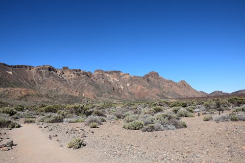 Free Expansive view of rocky mountains under a clear blue sky, offering stunning arid landscape beauty. Stock Photo