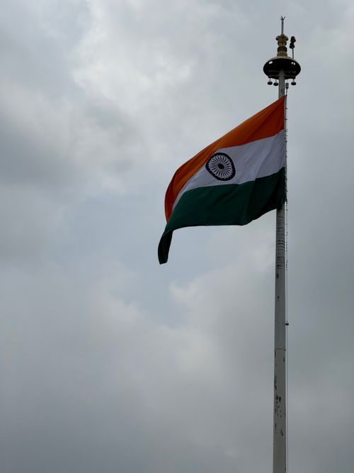 Free Indian national flag against a cloudy sky in Chandigarh, symbolizing pride and unity. Stock Photo
