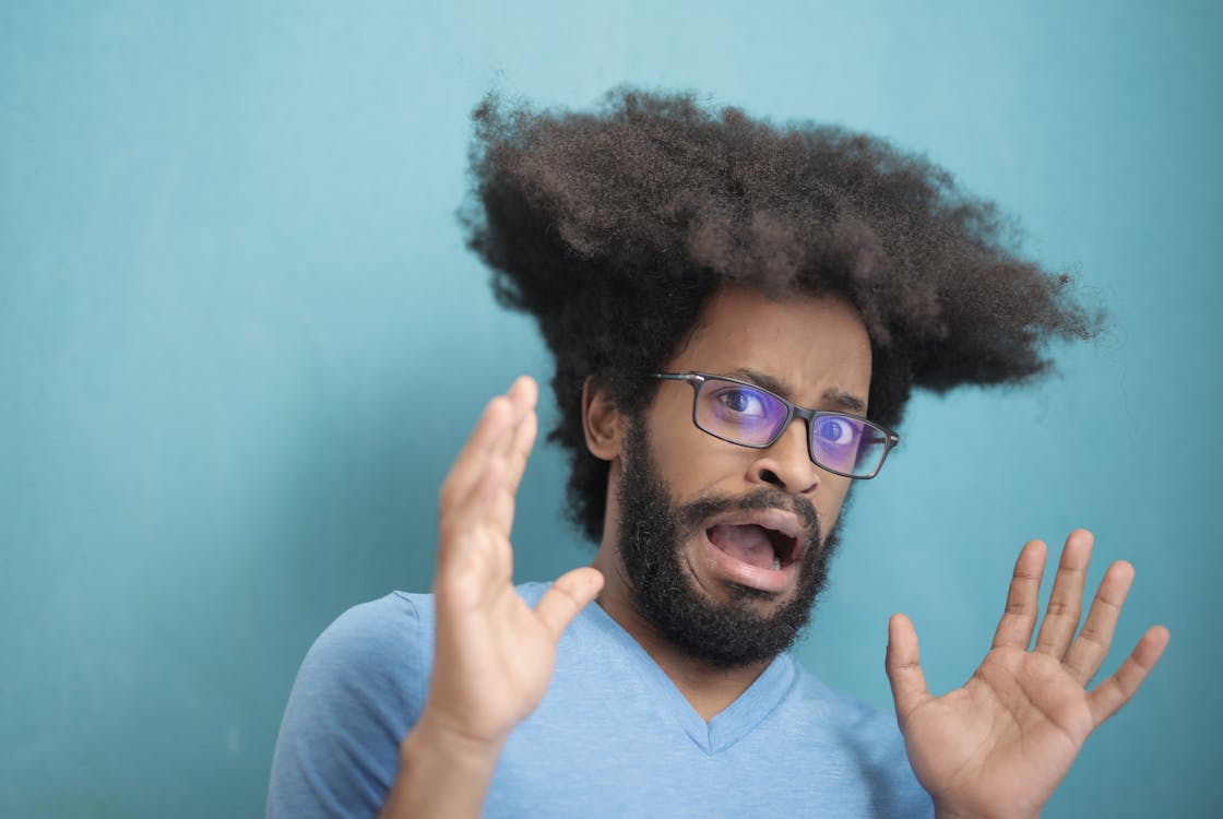 Man in Teal V Neck Shirt Wearing Black Framed Eyeglasses